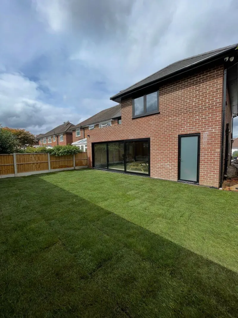 Completed brick house extension with large black framed glazed doors