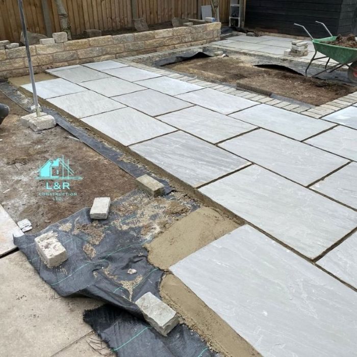Completed garden patio with large grey paving slabs and lawn