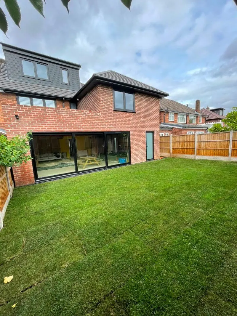 Completed rear brick extension with large glazed doors and lawn