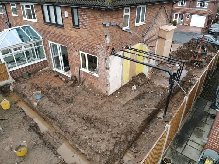 Foundation excavation and ground preparation beside a residential property